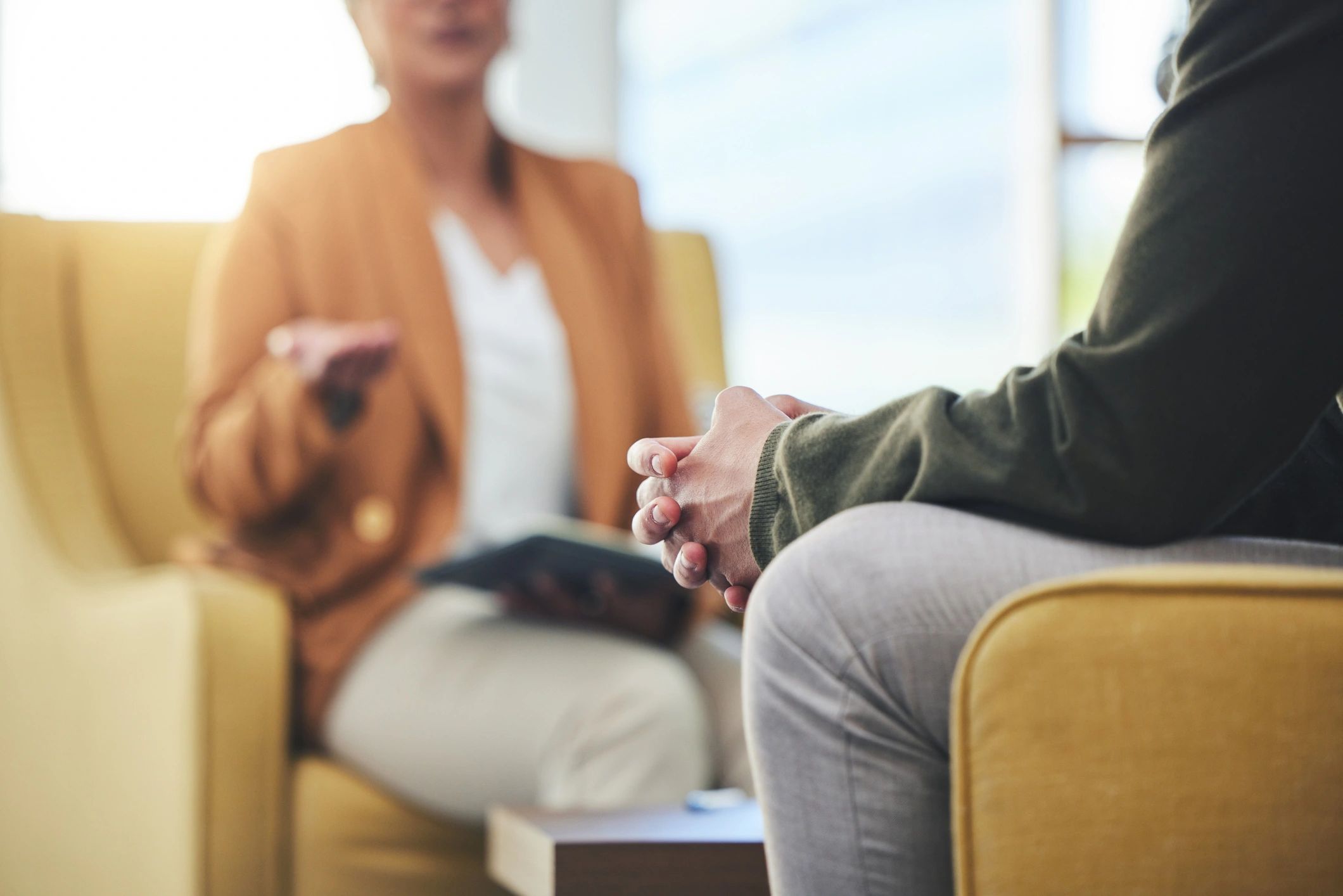 Couple holding hands and talking to a therapist